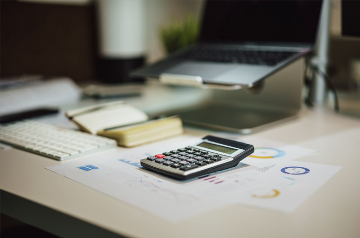 Rental owner reviewing a monthly property statement with a calculator