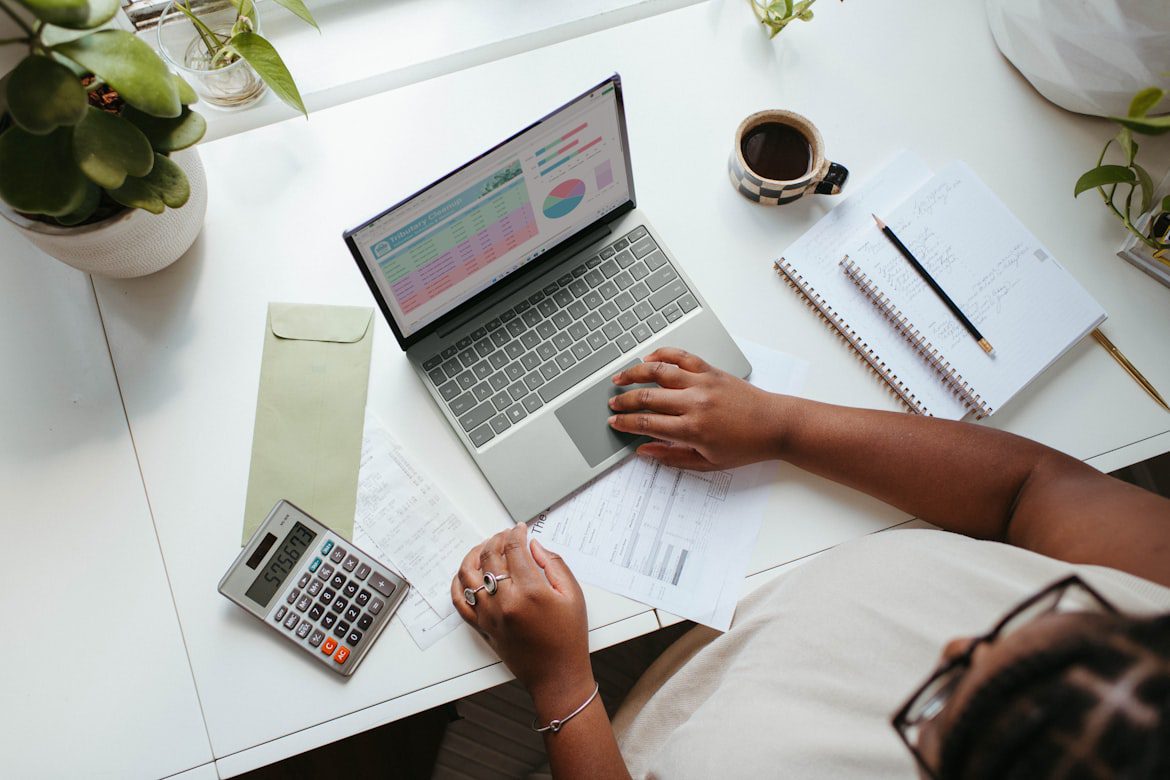 Desk with calculator and budget paperwork, representing AIM's flat fee tenant placement pricing for Treasure Valley rentals